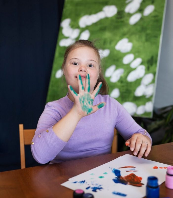 medium-shot-girl-with-down-syndrome-painting_23-2149632450